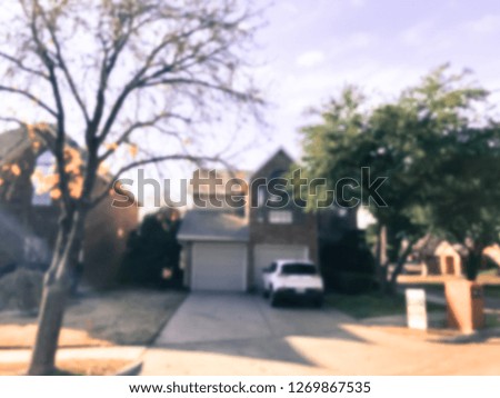 Motion blurred single family house with attached garage and parked car in Texas, America