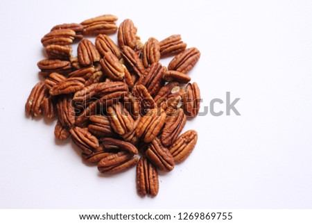 A close-up picture of organic pecans on a white background