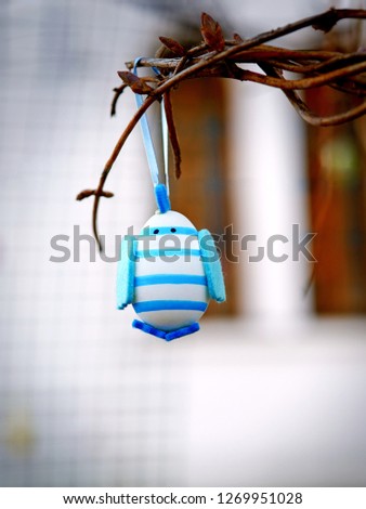 Cute blue chick hanging near the church. Decoration on eastertide. Easter egg bird