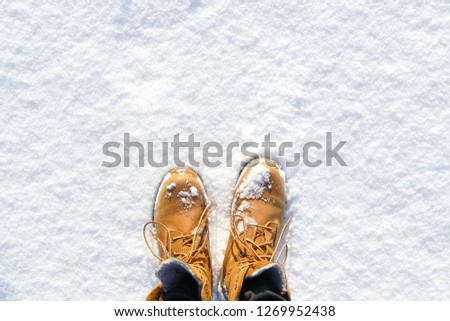 Top view of shoes / boots footprint in fresh snow. Winter season.