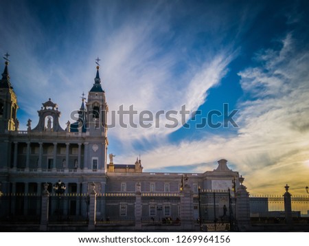 A sunset photo of the exterior facade of the Almudena Cathedral catholic church as seen from the Armory square of the Royal Palace of Madrid, or Palacio Real, in winter in Madrid, Spain, Europe.