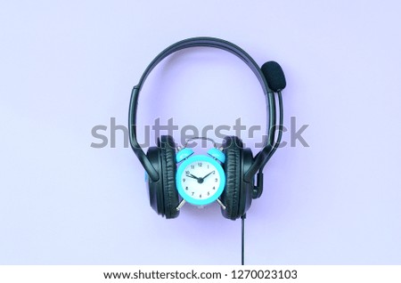 Concept of time to listening music. Alarm clock and headphones
