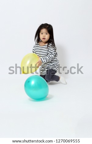 The little Asian girl on the white background.