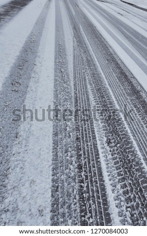 tire tracks in snow covered road                   