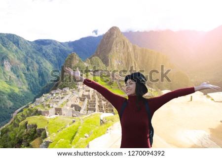 Young beautiful traveler standing with happy emotion with Machupicchu background.
