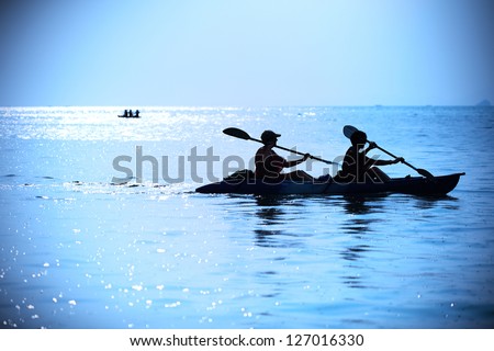 Silhouette of woman kayaking Royalty-Free Stock Photo #127016330