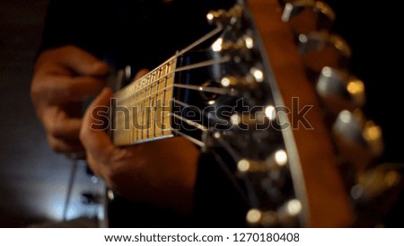 musician playing guitar on record at studio . closeup