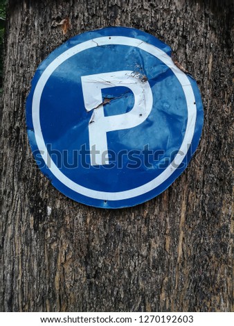 parking sign posted on the tree trunk background
