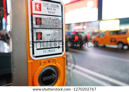 Pedestrian crossing button panel with traffic backdrop in Manhattan, New York, United States