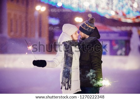 Loving couple hugging on skating winter rink. Concept of Christmas holidays.