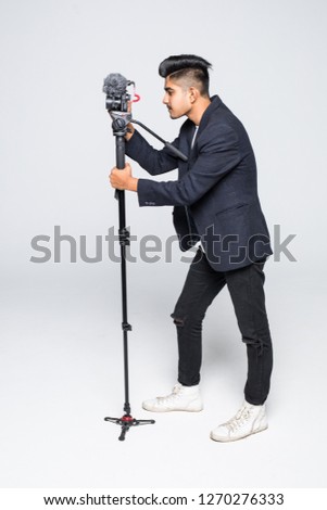 Young indian man video camera operator isolated on white background.