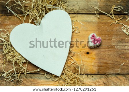 white, simple heart cut from wood on a romantic, simple rustic background, with space for text