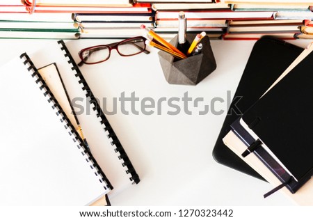 Stack of books, textbook, laptop, glasses in office business background for education learning concept