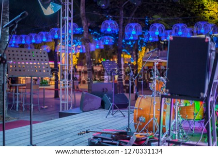 modern concert stage with musical instruments, bright neon lights,
