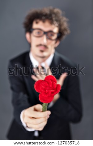 Boy with glasses is donating a fabric red rose