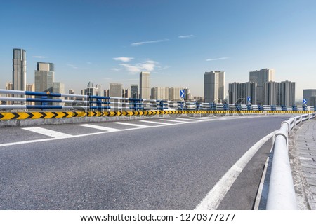 empty asphalt road with city skyline