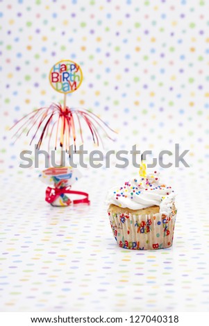 Image of a cupcake with birthday sign over polka dots.
