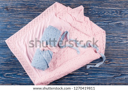 knitted blanket for newborns lying on a blue wooden surface