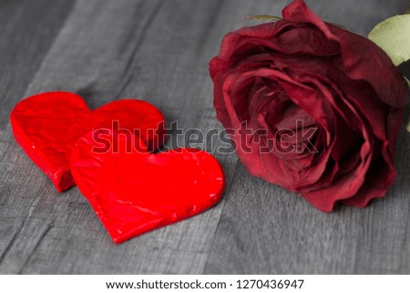 Valentine's Day. Two red heart shape and red rose flower on wooden background