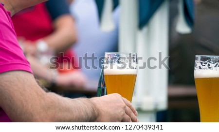 Man in the beer garden is drinking cool beer