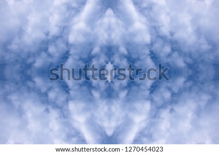 A symmetrical pattern formed by clouds in the sky. The image with the mirror effect. Amazing seamless pattern of clouds texture