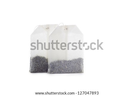Close-up shot of two teabags on white background.