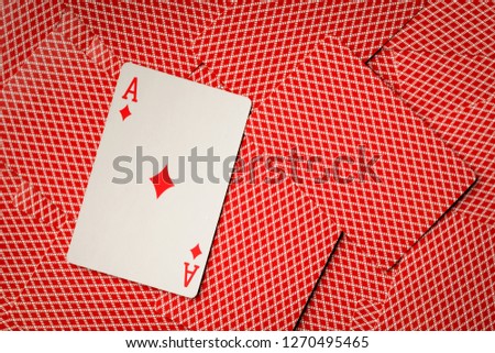 Ace diamonds on cards with red back background.