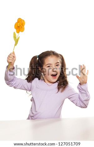 a nice little girl is playing with an artificial flower on white background