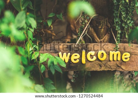 Wooden sign and write the word welcome when accepting