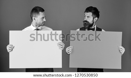 Men with beards hold boards on blue background. Businessmen with questioning faces hold green and pink sign boards, copy space. Advertisement or commercial posters. Business and presentation concept