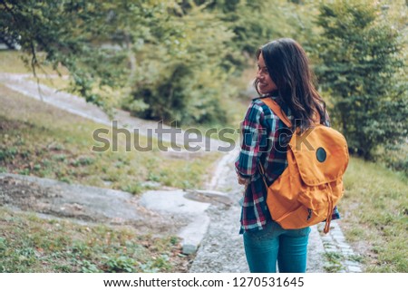 A young woman enjoys walking in the forest.At the same time he takes pictures of the forest.