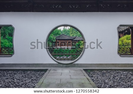Path leading to a moon gate with view of traditional Chinese building, in Guo's Villa (Guo Zhuang), a Chinese garden, near West Lake, in Hangzhou, China Royalty-Free Stock Photo #1270558342