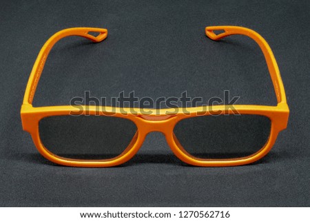Orange 3 Dimensional glasses on a dark grey background
