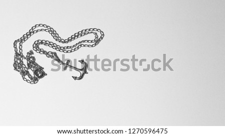 anchor necklace pendant in black and white picture with copy space for text. Accessory worn by man and woman. An anchor means the need to be focused 