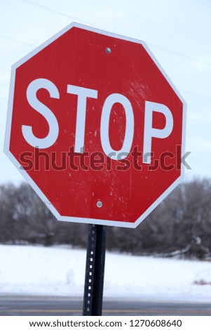 Red stop sign in the middle of winter with snow on the ground.