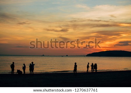 People in silhouette enjoying the view of amazing sunset in krabi