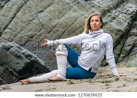 Young attractive women doing yoga on the beach in San Francisco with the Golden Gate Bridge in the background. 