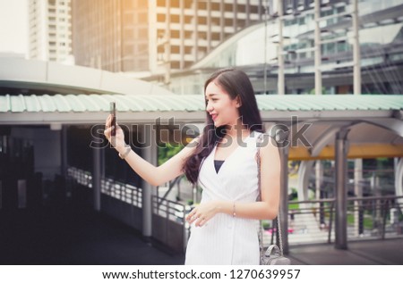 Portrait beautiful asian woman selfie with mobilephone and walking in the city,Female confidence happy and smiling,Lifestyle concept