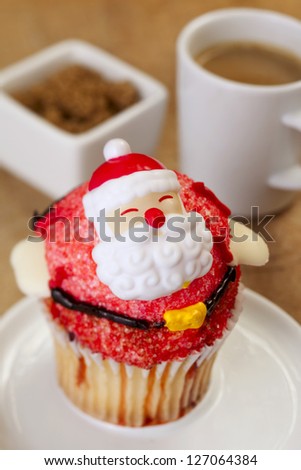 Flavorful Santa cupcake with biscuit and coffee at the back
