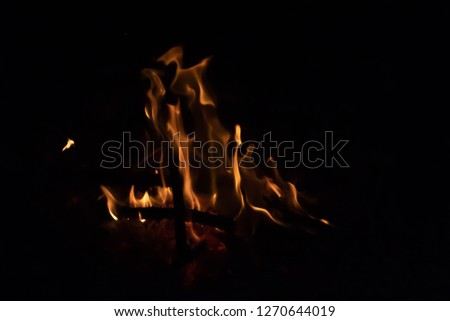 A beautiful yellow fire with a black background at night