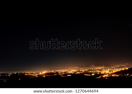 A distant picture of a group of houses illuminated at night