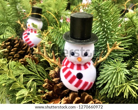 Snow man surrounded with pine leave for winter decoration
