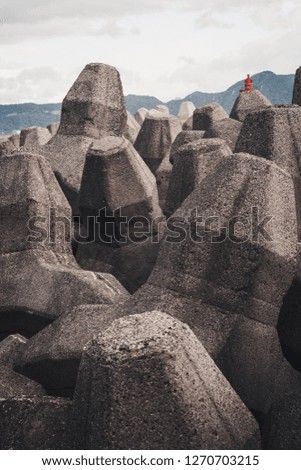 Detail of the breakwater on the port of town in north Taiwan. Far a way you can see small red lighthouse and mountains.