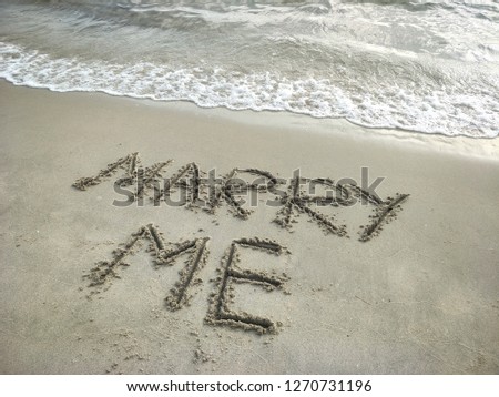 Marry me text on the beach 