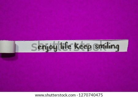 Enjoy life keep smiling, Inspiration, Motivation and business concept on purple torn paper