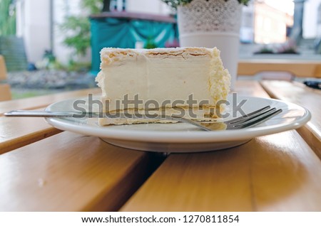 Close-up of Polish Papal Cream Cake in plate on table.  Royalty-Free Stock Photo #1270811854