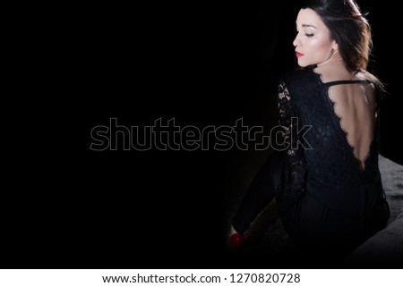 Woman sitting on sofa in dark background