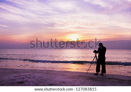 Photographer take a photo on the beach,silhouette shot