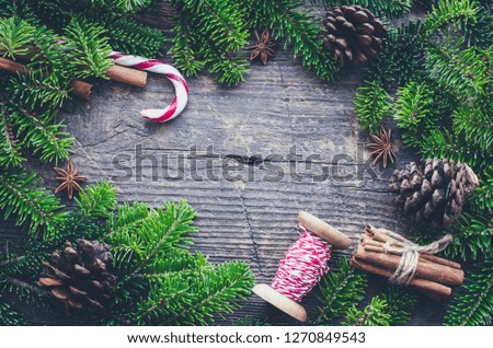 Christmas frame from fir tree branches and decorations on old wooden background with space for text. Merry Christmas and Happy New Year. Xmas concept. Top view. Flat lay. Copy space.