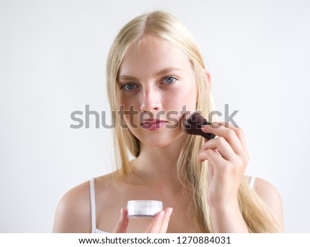 Makeup brush powder woman applying cosmetics natural portret 